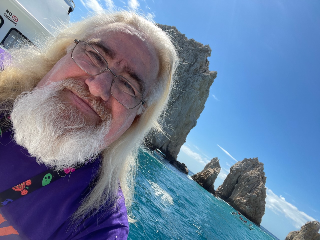 Lawrence Brody on a boat excursion in Cabo San Lucas with turquoise ocean and rock formations
