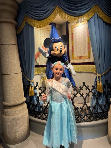 Granddaughter in a princess dress meeting Princess Minnie Mouse at Disney World