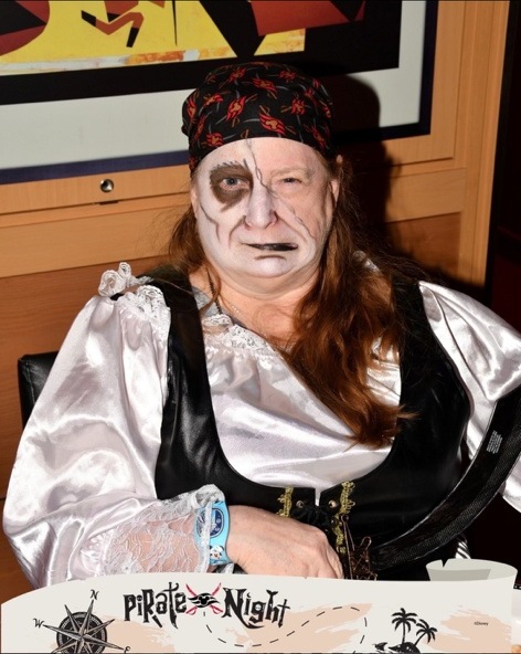 Lawrence Brody in full pirate costume with face paint and a Pirate Night sign aboard the Disney Fantasy