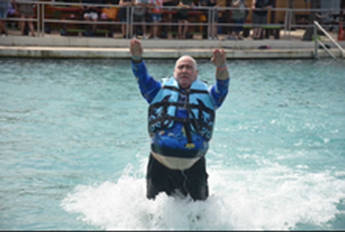 Lawrence Brody with arms raised in turquoise water during a Disney Fantasy dolphin push excursion — sequence 3 of 3