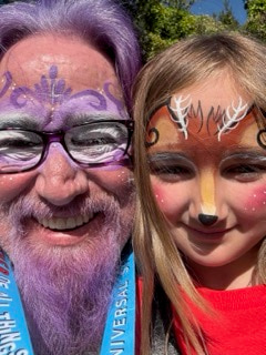 Lawrence Brody and granddaughter with face paint at a theme park