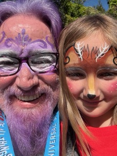 Lawrence Brody and granddaughter with face paint at a theme park